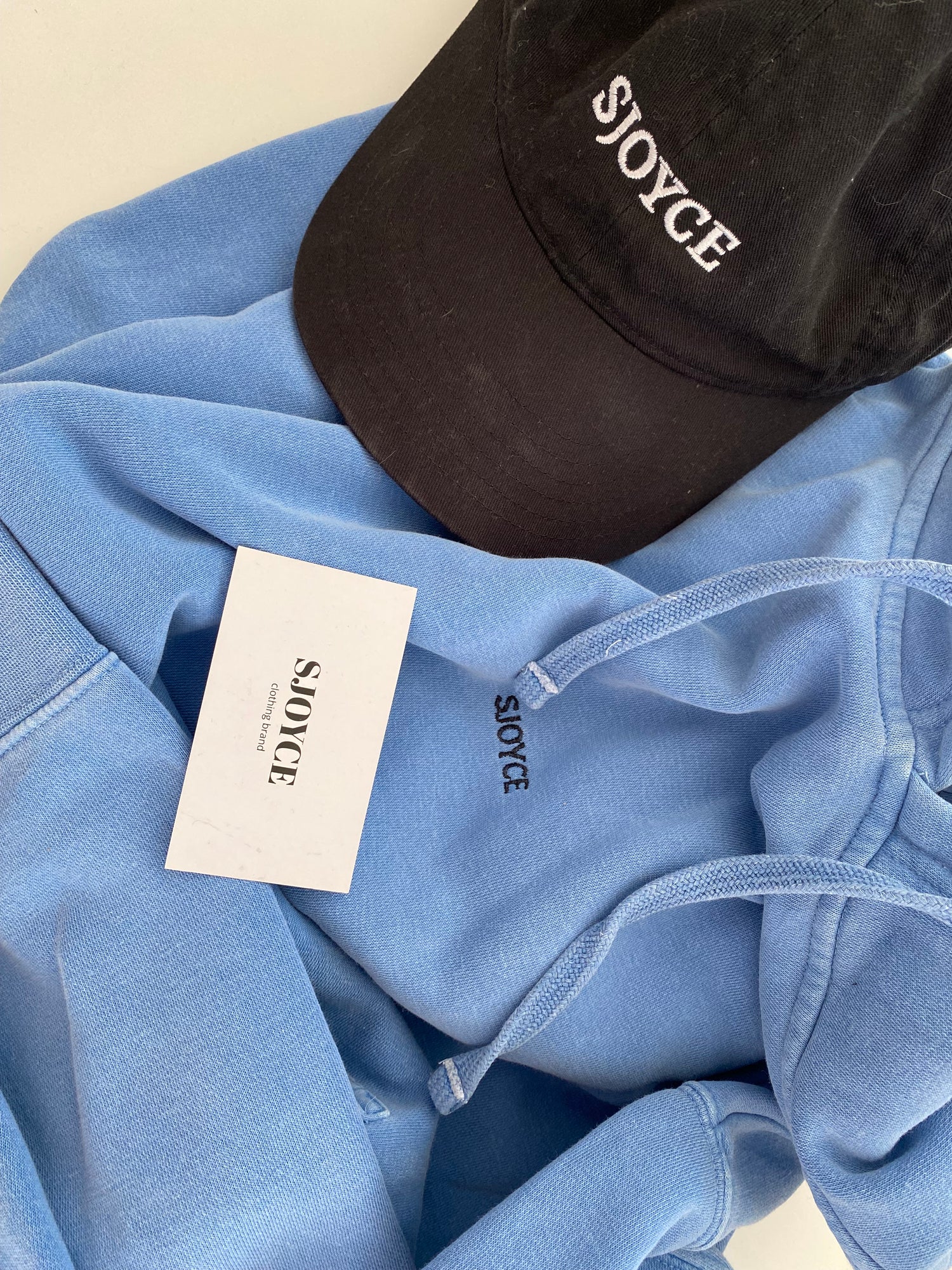 SJOYCE hoodie made of print material, featuring a comfortable fit and stylish design, displayed in a close-up shot.